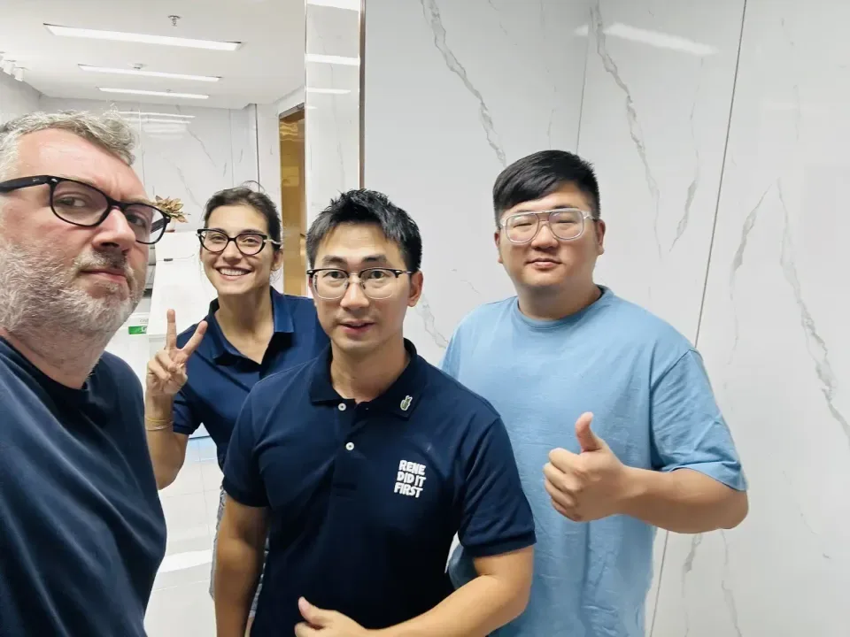 Cuatro personas posando para una foto en el recibidor de una oficina durante la visita de un cliente